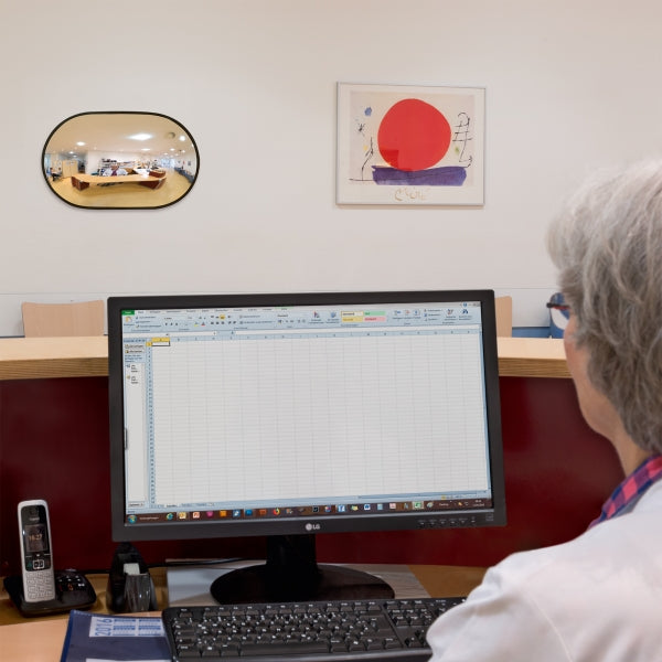 Oval mirror giving bigger view of an office