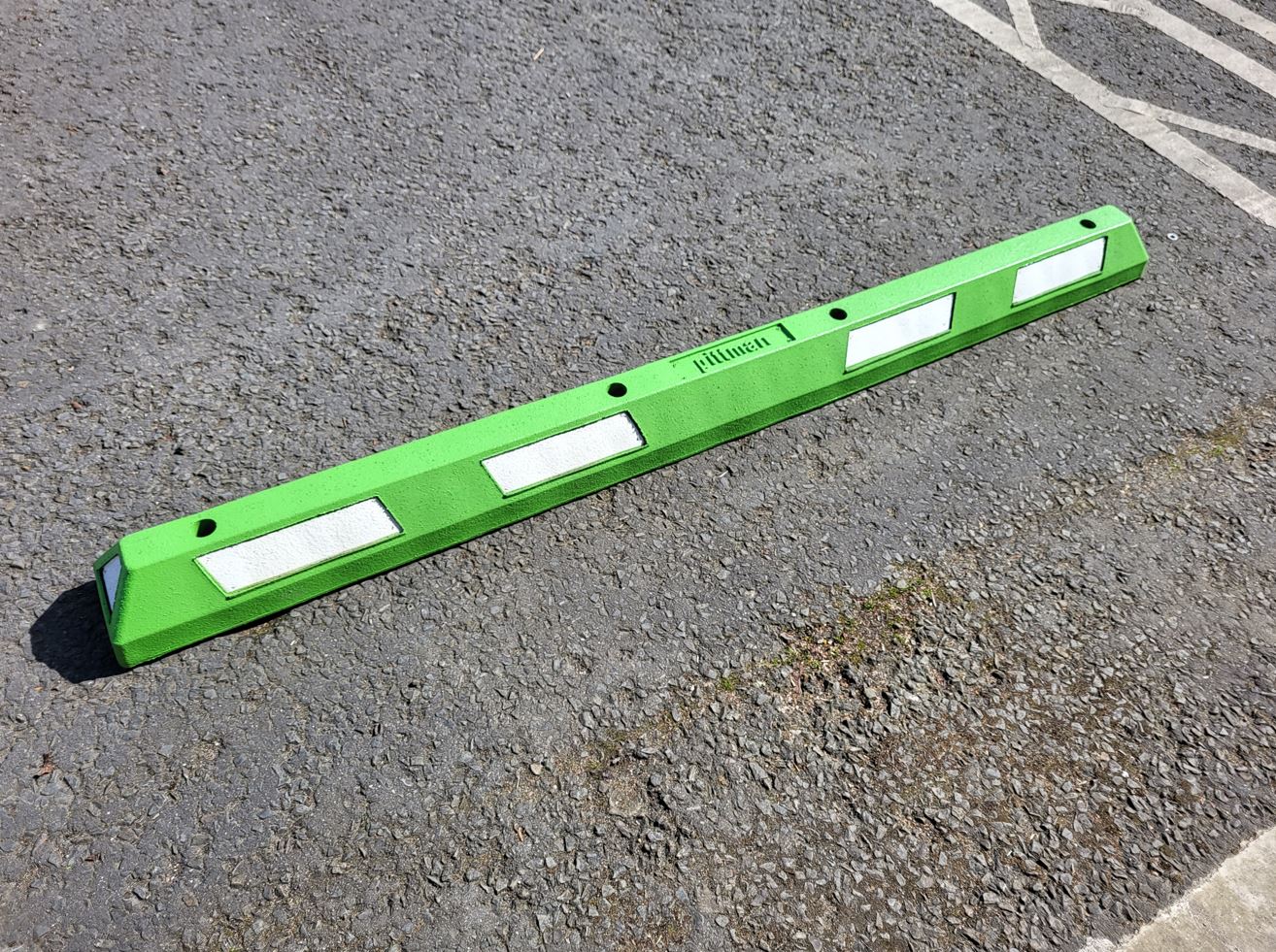 Green XPT Wheel Stop installed into tarmac